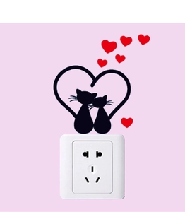 Detail of two black cat silhouettes forming a heart with red heart wall stickers