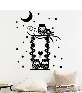 Detail of cartoon owl wall decal with stars and moon in a cozy reading corner