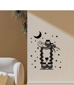 Detail of cute owls on a flower swing wall decal with moon and stars in nursery room
