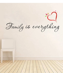 Détail du sticker mural Family is everything avec cœur rouge sur un mur minimaliste