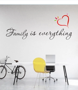 Détail du sticker mural Family is everything avec cœur rouge dans un salon moderne clair