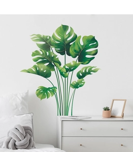 Detail view of large green palm leaf wall stickers in a minimalist Nordic bedroom setup