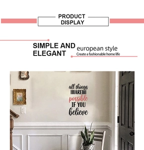 Détail d'un sticker mural motivant avec police artistique noire et rose sur un mur de salon