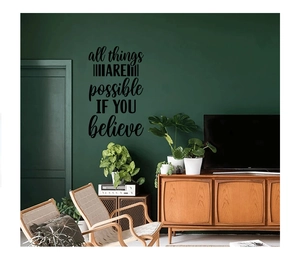 Détail du sticker mural All things are possible sur un mur vert foncé de salon