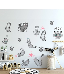 Detailed view of gray cartoon cat wall decals with pink hearts on a smooth wall surface