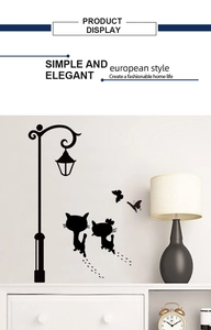 Detalle del vinilo decorativo de gato negro y farola sobre pared blanca de sala moderna
