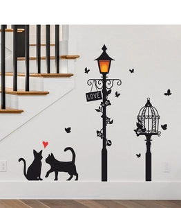 Detail of DIY wall stickers featuring black cats silhouettes and lamp post on white wall