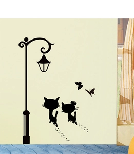 Detalle del adhesivo de pared de PVC de gato negro y farola en una pared beige lisa