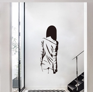 Minimalist black silhouette wall sticker of a female figure in a white hallway setting