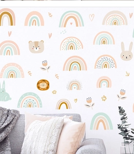 Close-up of Boho style rainbow and animal wall decals above a cozy sofa in a child room
