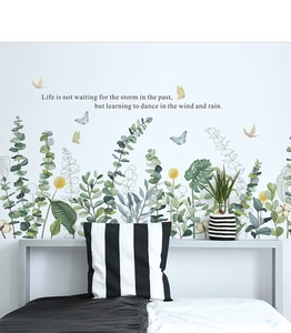 Wandsticker mit grünen Blättern und Schmetterlingen über dem Bett im Schlafzimmer