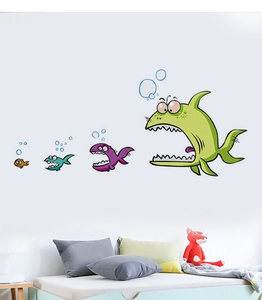 Detail showing cartoon fish wall stickers on a white wall above a bed with plush toys