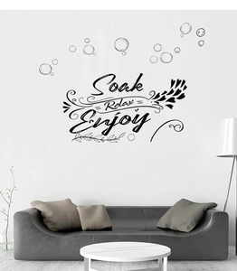 Artistic wall decal featuring Soak Relax Enjoy text with bubbles in a modern living room