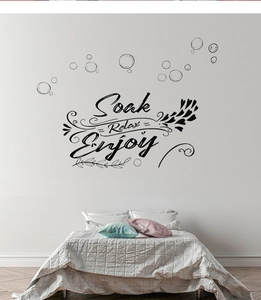 Detail of Soak Relax Enjoy wall decal with bubbles and hearts above a cozy bed