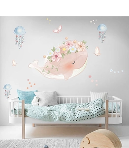 Detail of pink whale wall decal with floral crown and blue jellyfish in nursery decor