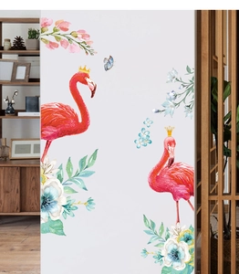Detail view of flamingo wall stickers with floral elements and golden crowns on a white wall