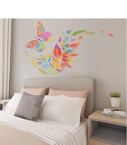 Vibrant rainbow butterfly and feathers wall sticker on a cozy bedroom background