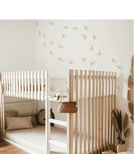 Detail of bohemian brown dandelion wall decals scattered on a clean white nursery wall