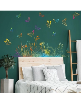 Vibrant butterfly and grass wall stickers displayed on a dark green bedroom wall