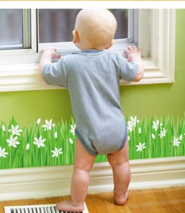 Detail der Blumen-Fußleistenaufkleber mit grünem Gras und weißen Lilien im Kinderzimmer