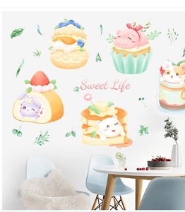Close-up of cute cartoon animal cake stickers with Sweet Life text on a white wall