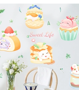 Close-up of cute cartoon animal cake stickers on white wall with Sweet Life text