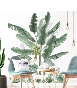 Detailed view of tropical banana leaf wall decals in a modern living room setting