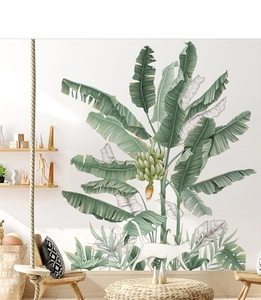 Detail of banana leaf wall stickers with a white cat silhouette in a cozy nursery