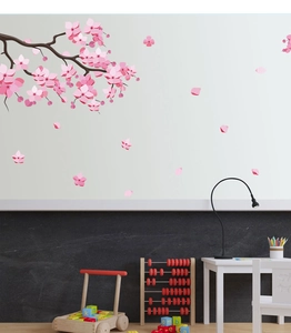 Detail of pink cherry blossom wall stickers on a minimalist Nordic style bedroom wall