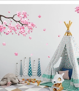 Detail of pink cherry blossom wall stickers with falling petals in a cozy nursery room