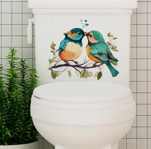 Close-up of bird and floral branch wall decals on a white ceramic bathroom tile surface