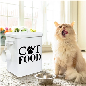 Close-up of a white metal cat food storage container with a scoop and lid in a home setting