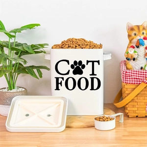 White minimalist cat food storage tin with scoop and black cat paw design on wood