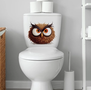 Close-up of a cute cartoon owl sticker applied to a white ceramic toilet tank in bathroom