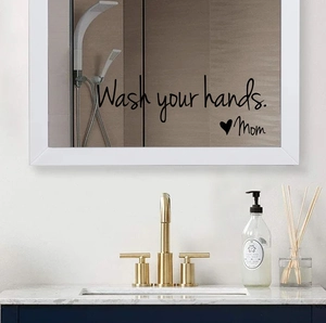 Detail view of Wash Your Hands Mom wall decal applied to a bathroom mirror surface