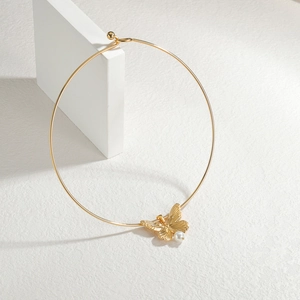 Collana girocollo dorata con ciondolo a farfalla e perla su espositore geometrico