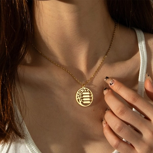 Collana dorata con ciondolo albero della vita indossata da modella in luce naturale
