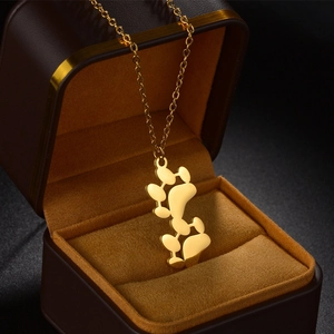 Polished gold titanium steel cat paw necklace displayed in an elegant jewelry gift box