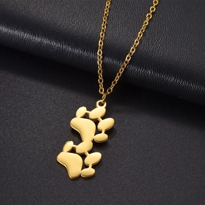 Detailed close-up of golden paw print necklace on premium black leather background