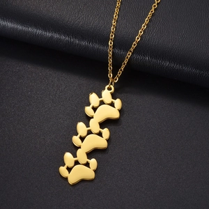 Close-up of golden titanium steel necklace with triple animal paw print pendant detail