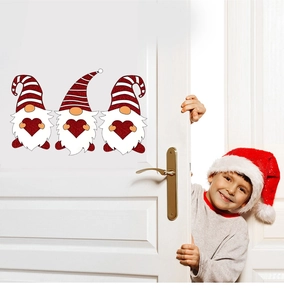 Detail of cute Christmas gnome wall stickers with red hearts on a white bedroom door
