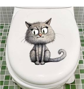 Detailed view of grey cartoon cat sticker with funny expression on white toilet lid