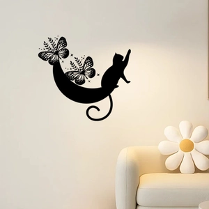 Detailed view of black cartoon cat and moon wall decals on a white living room wall