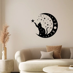 Close-up of black cat silhouette sitting on a crescent moon wall sticker in a living room