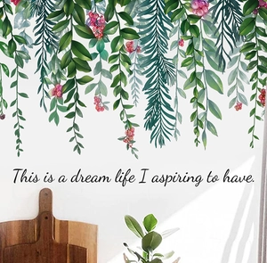 Détail de stickers muraux avec branches vertes, baies rouges et citation décorative