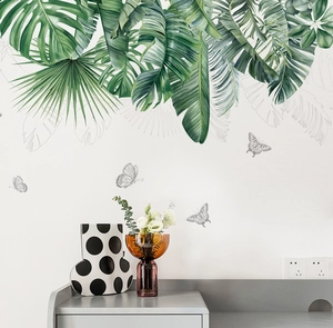 Detailed view of tropical monstera and palm leaf wall decals in a modern living room