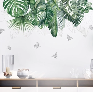 Detail of tropical monstera and palm leaf wall stickers with gray butterfly accents