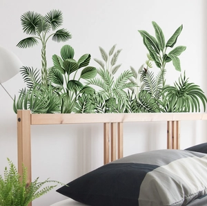Detail showing tropical palm and monstera leaf wall stickers in a cozy bedroom setting