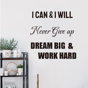 Close-up of black motivational wall stickers showing Never Give Up and Dream Big quotes