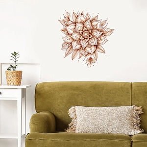 Detail of vintage mandala wall sticker on a white wall above a dark green velvet sofa